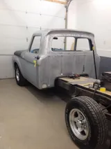 Ford pickup cab in bare steel inside the shop