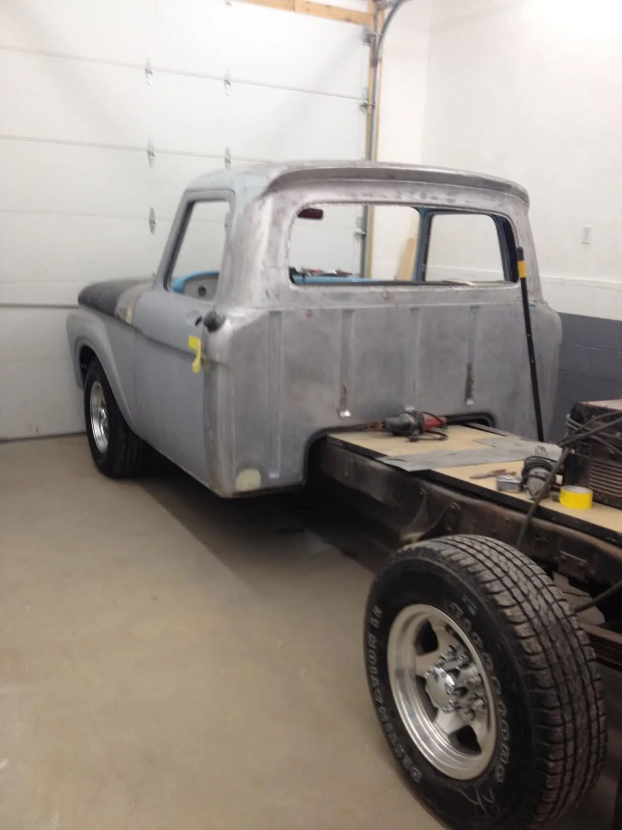 Ford pickup cab in bare steel inside the shop