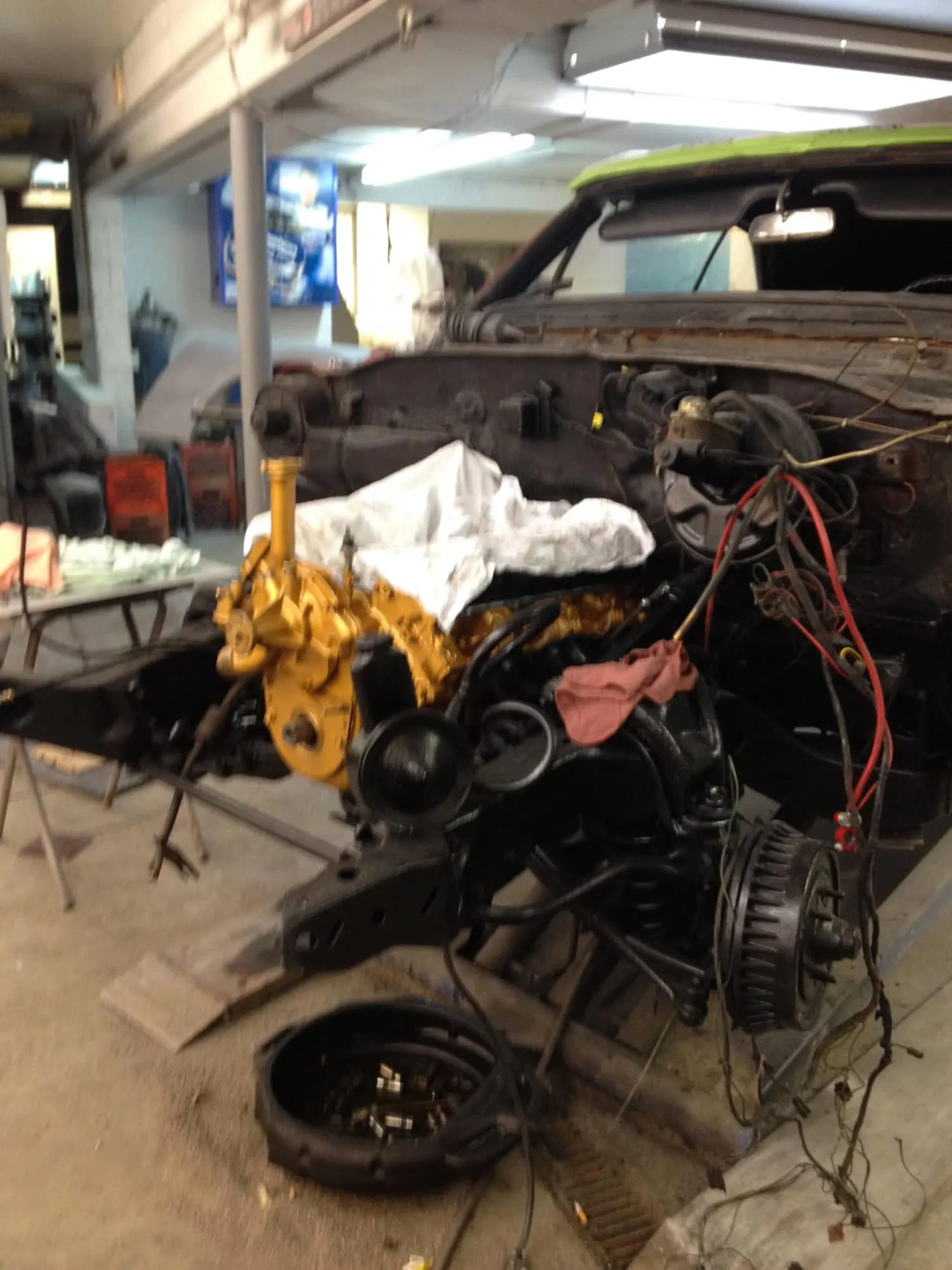 Classic Oldsmobile engine bay mid-restoration inside the shop