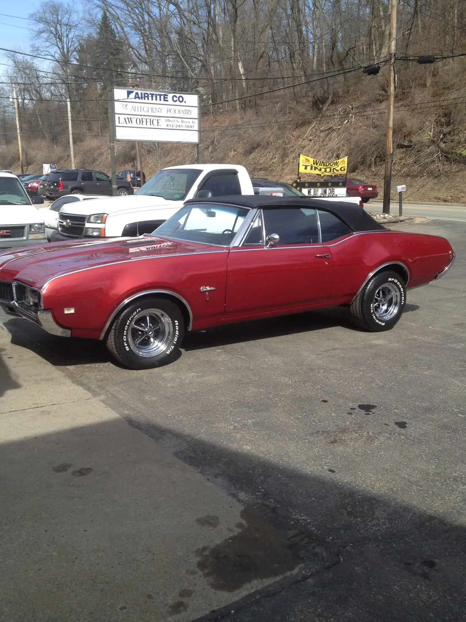 Finished red Oldsmobile convertible with black top on the shop lot
