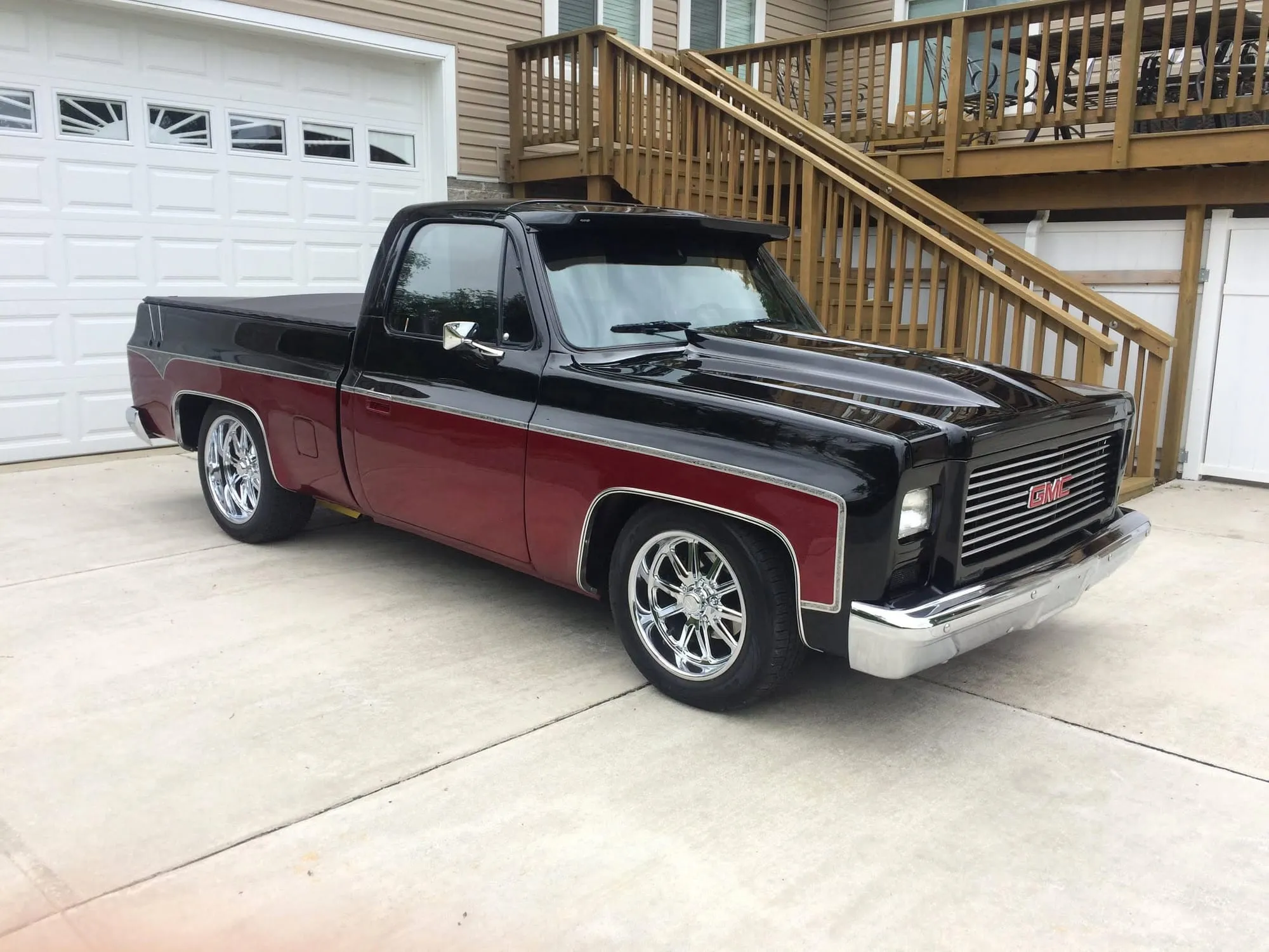 Two-tone black and maroon square-body Chevy pickup after a full repaint
